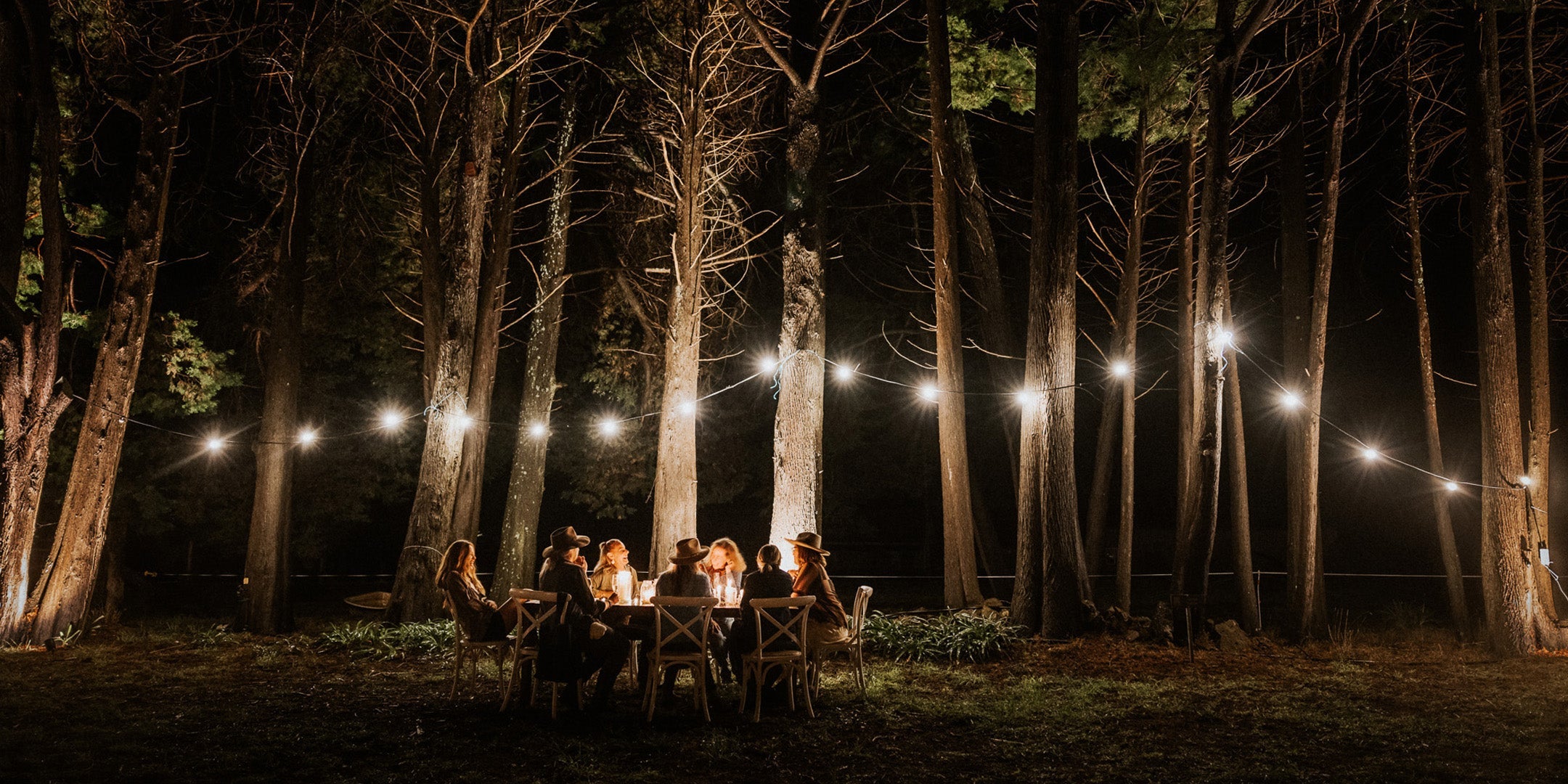 tattooed arm reaching from bed to tan escapee pouch with harmonica in it