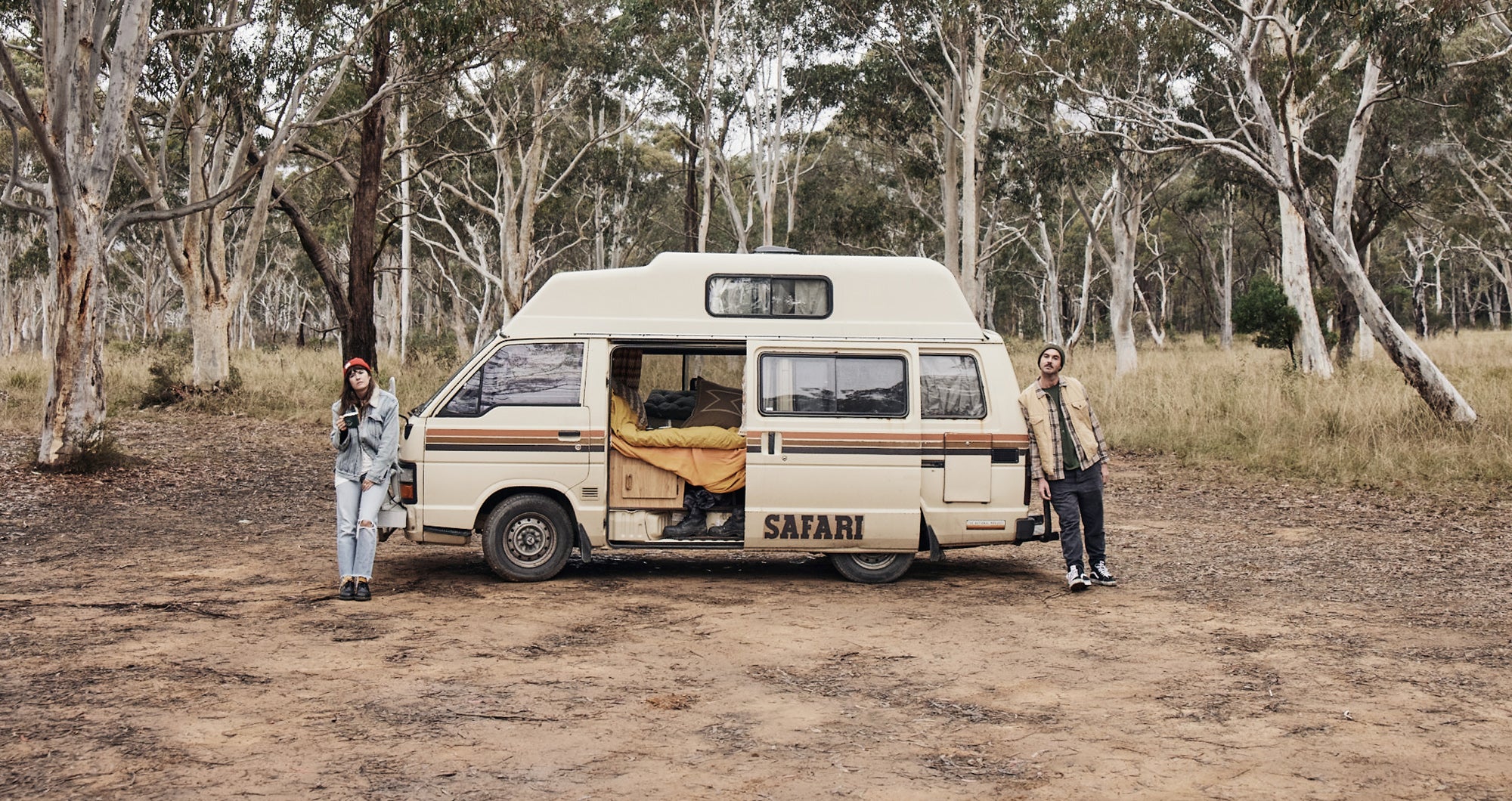 girl and guy at either end of a van in the australian bush